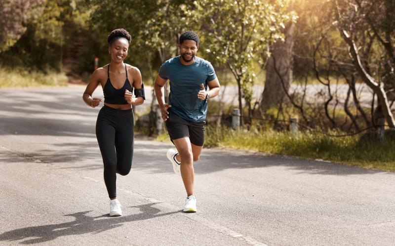 a man and woman running on a road